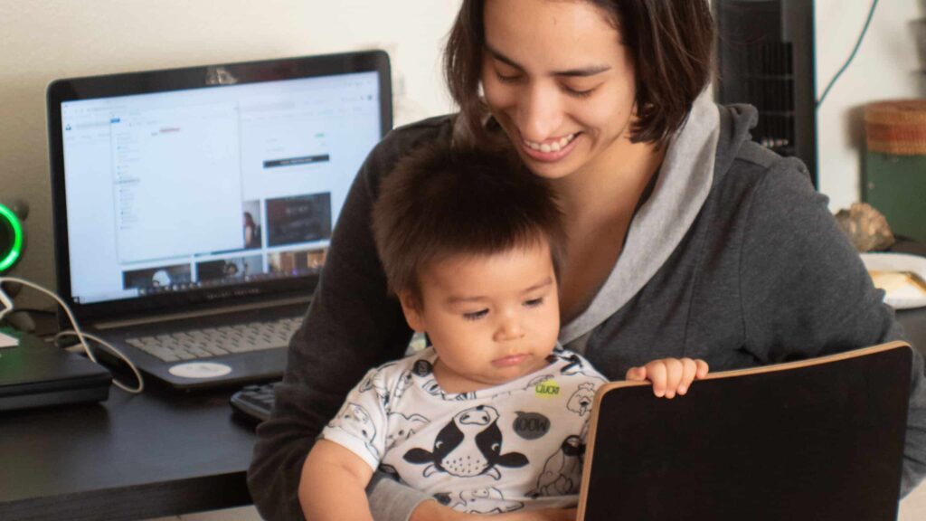 Mãe e filho sentados em frente ao computador