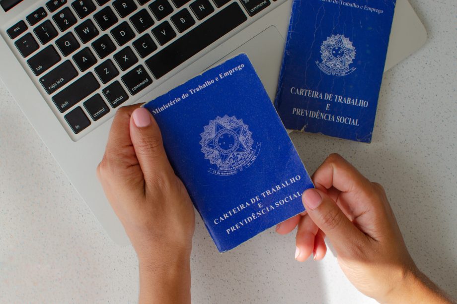 Brazilian Work Card. Translation 'Federative Republic of Brazil, Ministry of Labour'. Concept of FGTS, unemployment, PIS, salary, retirement, employee and Brazilian economy. Hand holding workbook.