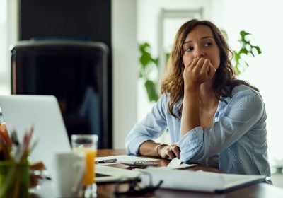 Young worried woman thinking of something while calculating her  home budget.